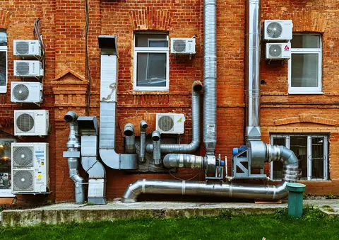 Exterior ducts and outdoor units on a brick building